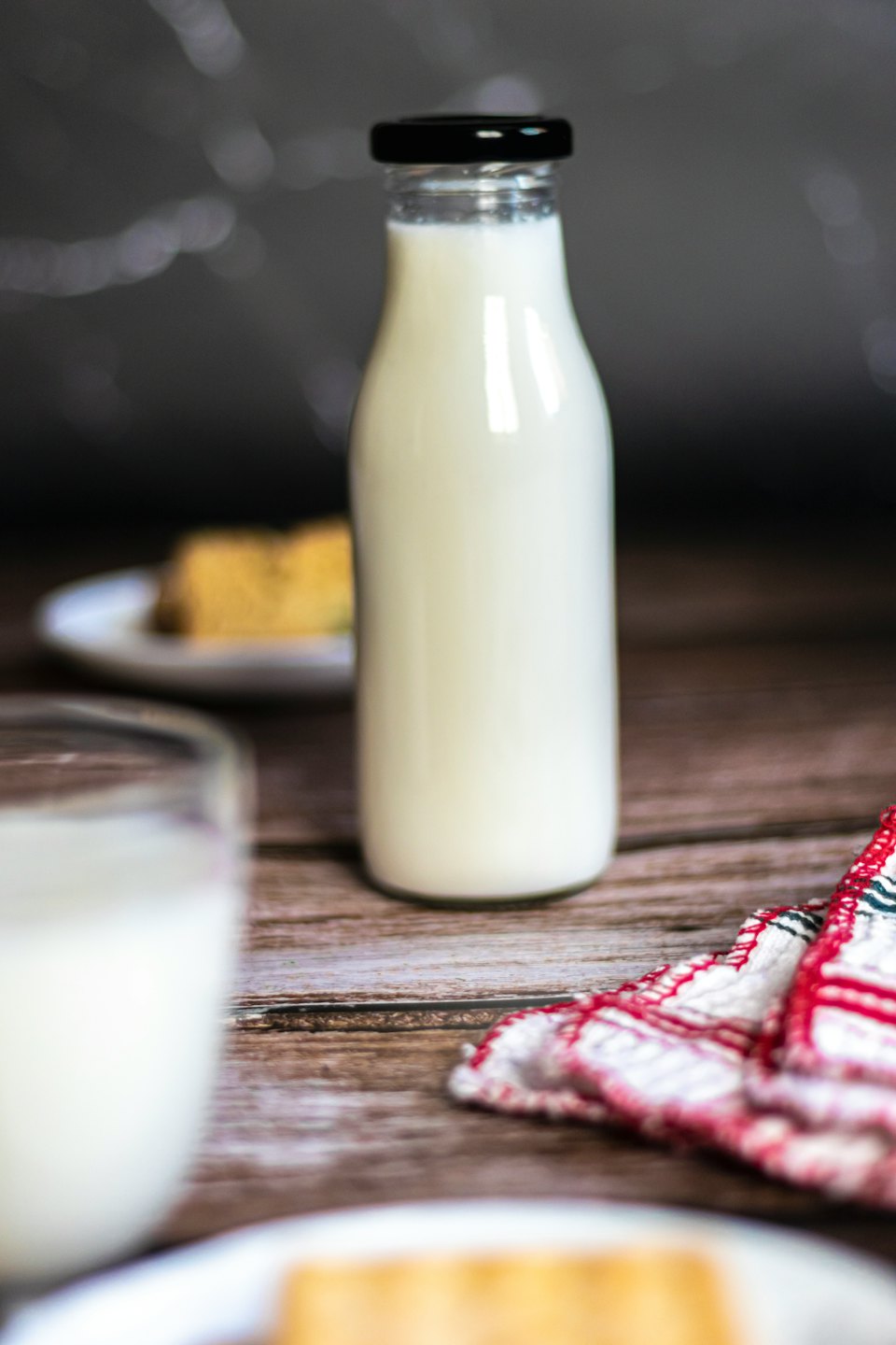 Bottiglia di vetro di latte su un tavolo di legno rustico.